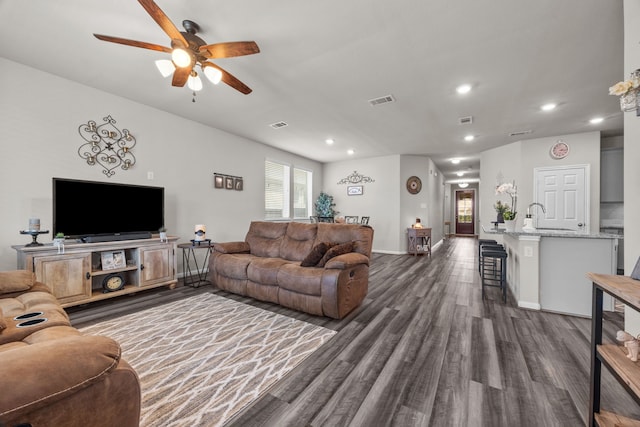 living area featuring recessed lighting, dark wood-style flooring, visible vents, and baseboards