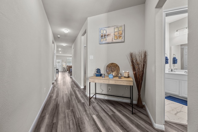 corridor featuring baseboards and dark wood-style flooring