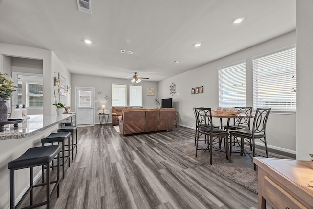 interior space featuring dark wood-style floors, baseboards, visible vents, and recessed lighting