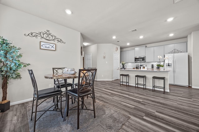 dining space featuring dark wood-type flooring, recessed lighting, visible vents, and baseboards