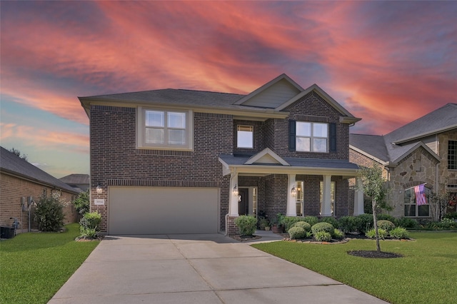 view of front facade featuring driveway, a front lawn, and brick siding