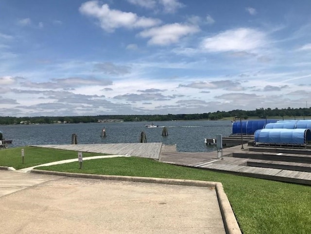 view of dock featuring a water view and a lawn