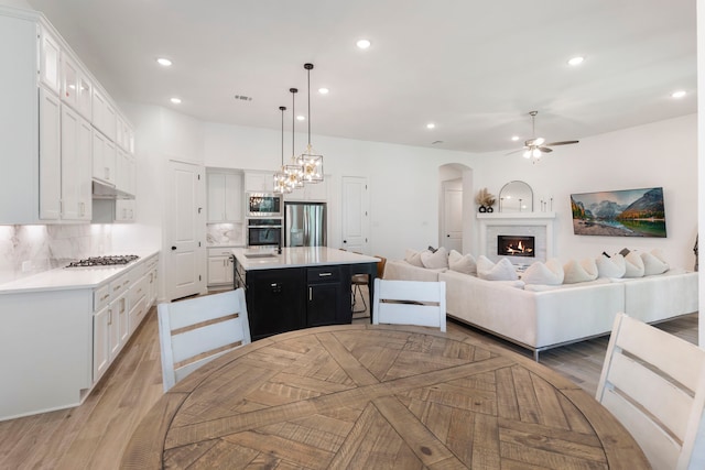 kitchen with white cabinets, appliances with stainless steel finishes, light countertops, and open floor plan