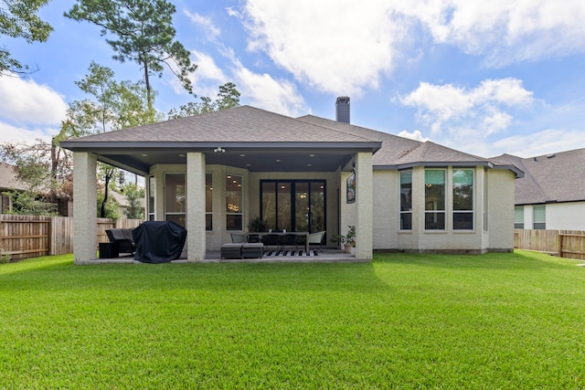 rear view of property with roof with shingles, a yard, a chimney, a patio area, and a fenced backyard