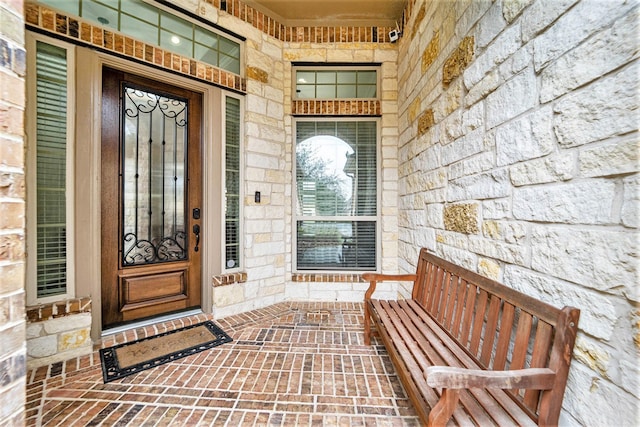 entrance to property featuring stone siding and brick siding