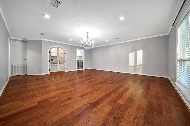 unfurnished living room featuring a textured ceiling, wood finished floors, visible vents, and a notable chandelier