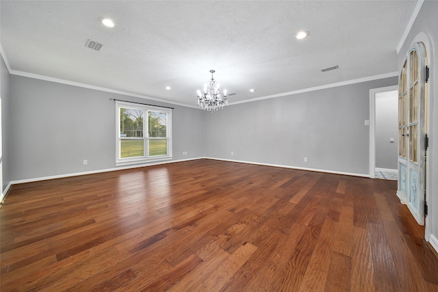 unfurnished room featuring visible vents, baseboards, dark wood-style floors, crown molding, and a notable chandelier