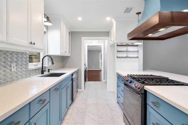 kitchen featuring blue cabinets, range with gas cooktop, a sink, and exhaust hood