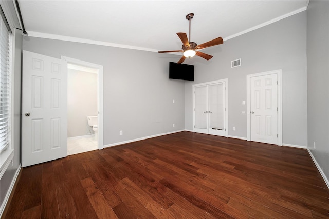 unfurnished bedroom featuring wood finished floors, visible vents, baseboards, multiple closets, and ornamental molding