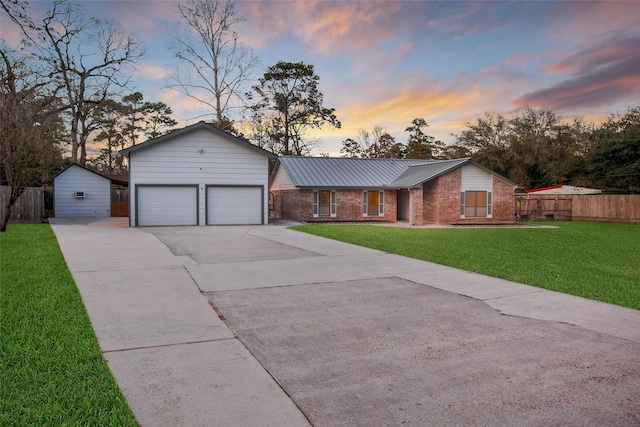 single story home featuring driveway, brick siding, a front lawn, and fence