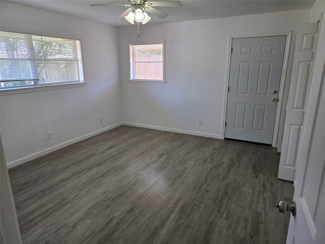 empty room with a ceiling fan, baseboards, and wood finished floors