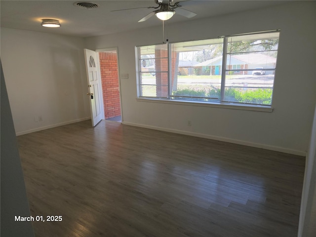 spare room featuring baseboards, visible vents, ceiling fan, and wood finished floors