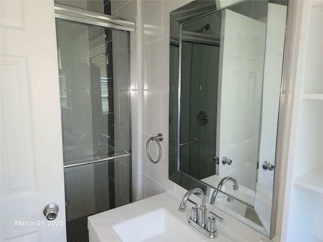 full bath featuring a tile shower and a sink