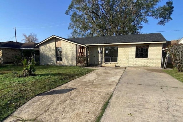 ranch-style house featuring brick siding and a front lawn