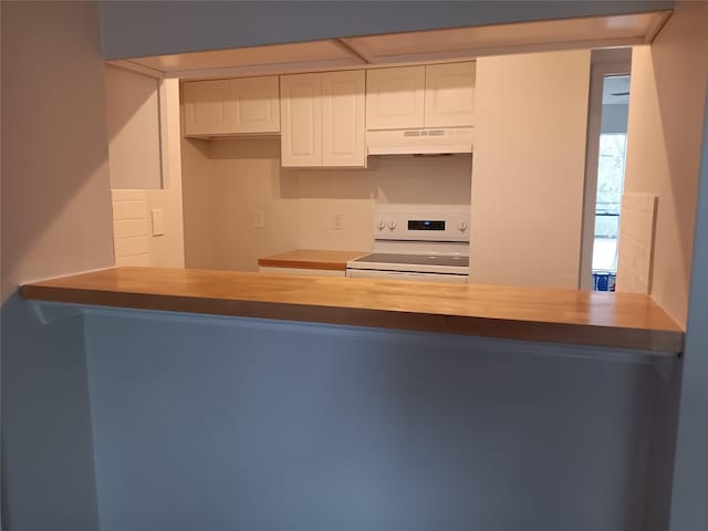 kitchen with white cabinets, white electric stove, under cabinet range hood, and a peninsula