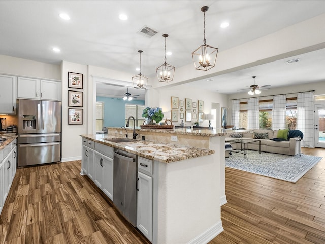 kitchen with visible vents, appliances with stainless steel finishes, open floor plan, and a sink