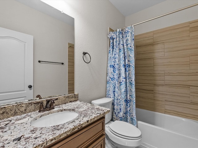 full bathroom with a textured wall, shower / bath combo, vanity, and toilet