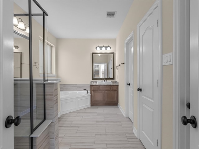 bathroom with visible vents, vanity, and a bath