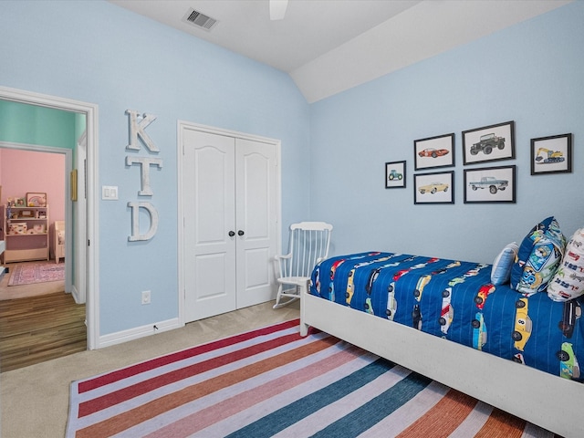 carpeted bedroom with baseboards, visible vents, a ceiling fan, vaulted ceiling, and a closet