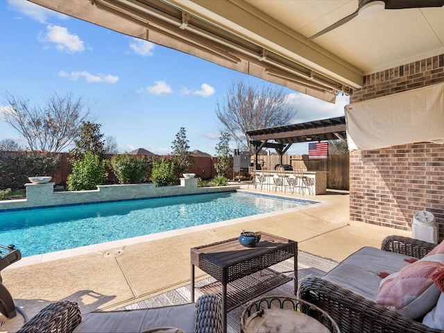 view of pool with a fenced in pool, a patio, outdoor dry bar, a ceiling fan, and a fenced backyard