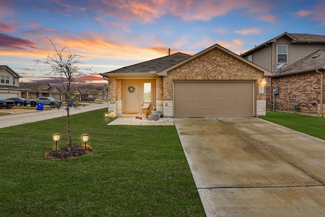 view of front of house featuring a garage, concrete driveway, brick siding, and a lawn