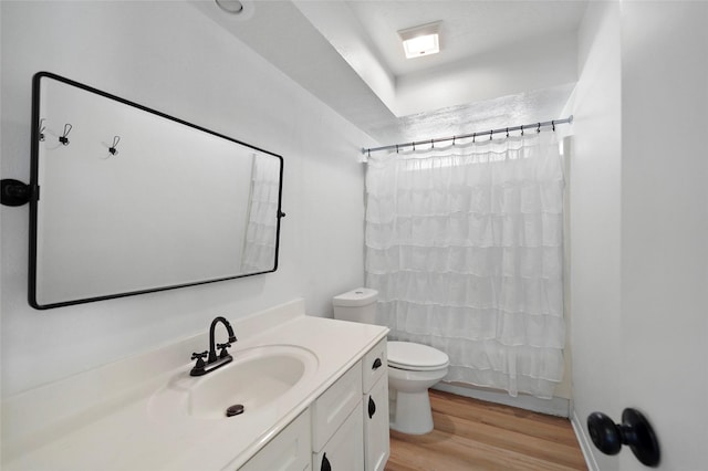 bathroom with vanity, a shower with shower curtain, wood finished floors, and toilet