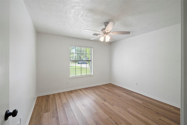 unfurnished room featuring a ceiling fan, a textured ceiling, baseboards, and wood finished floors