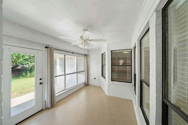 unfurnished sunroom with a ceiling fan