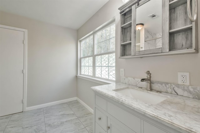 bathroom with marble finish floor, baseboards, visible vents, and vanity