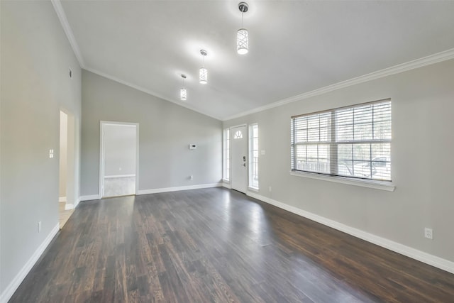 spare room featuring ornamental molding, vaulted ceiling, dark wood finished floors, and baseboards