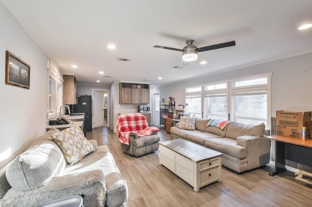 living room featuring light wood finished floors, recessed lighting, visible vents, ornamental molding, and ceiling fan