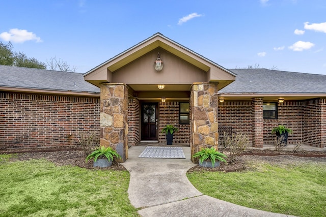 property entrance with stone siding, a shingled roof, and brick siding