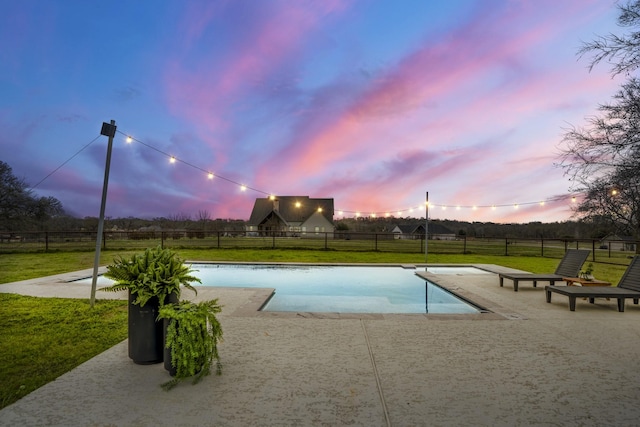 view of swimming pool featuring a patio, fence, a fenced in pool, and a yard