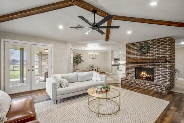 living room featuring lofted ceiling with beams, french doors, a fireplace, and wood finished floors