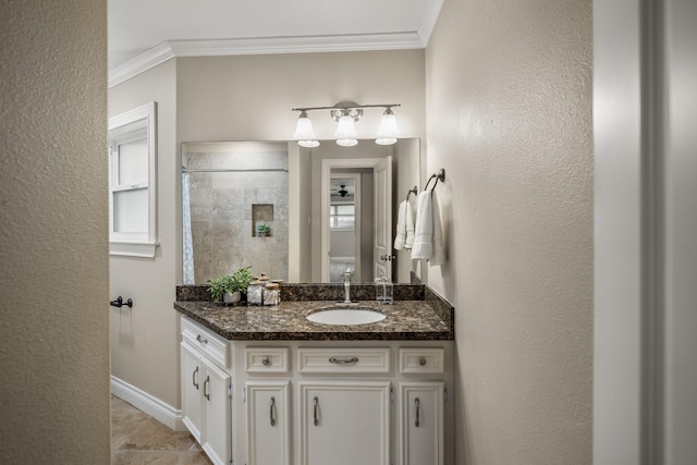 bathroom featuring baseboards, tiled shower, vanity, and crown molding