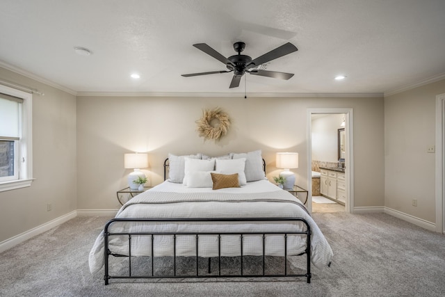 bedroom featuring baseboards, ornamental molding, ensuite bathroom, and light colored carpet