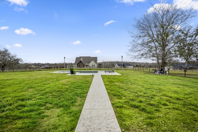 view of community with a yard and fence