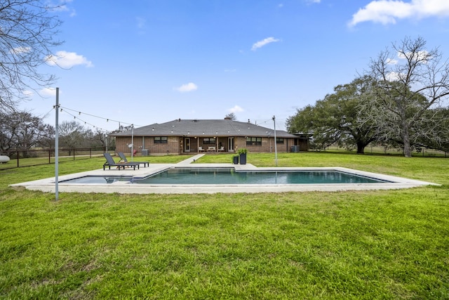 outdoor pool with fence, a patio, and a yard