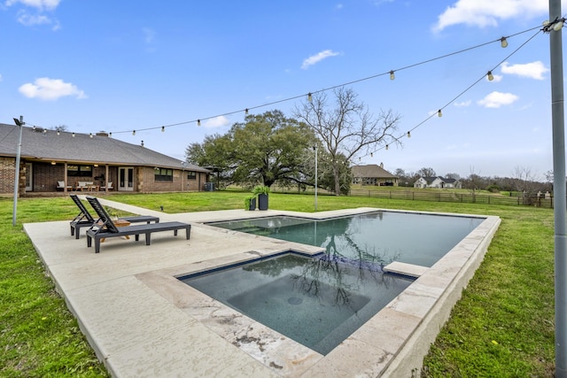 view of pool featuring a pool with connected hot tub, fence, a patio, and a yard