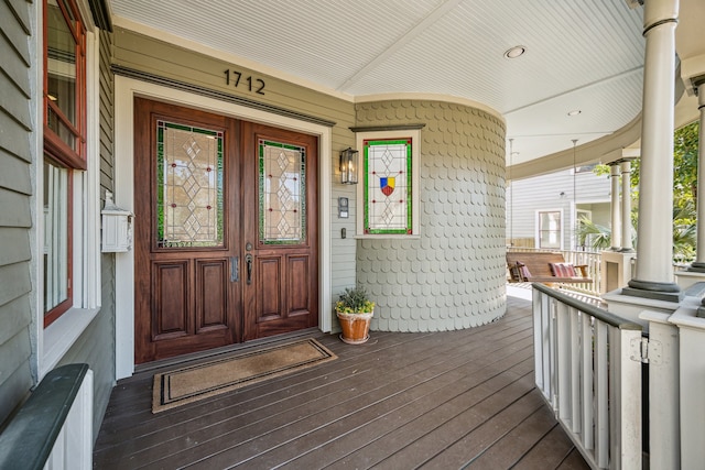 view of exterior entry with a porch and radiator heating unit