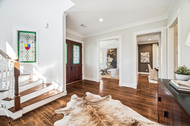 entryway with ornamental molding, wood finished floors, baseboards, and stairs