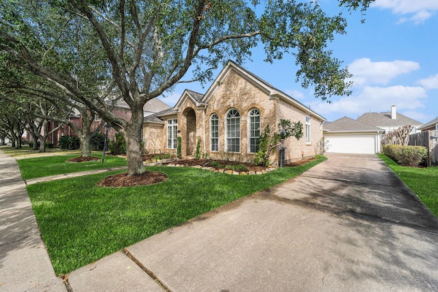 view of front of house featuring brick siding, a front yard, and fence