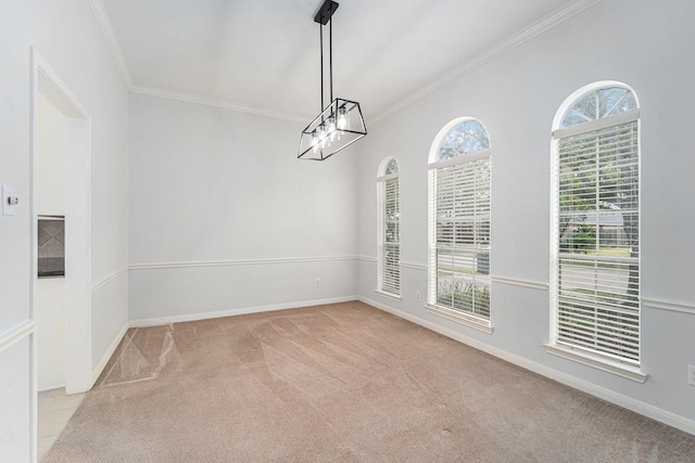 empty room with a chandelier, carpet, crown molding, and baseboards