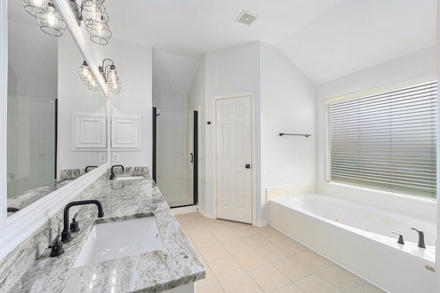 bathroom with tile patterned floors, visible vents, vaulted ceiling, a sink, and a bath