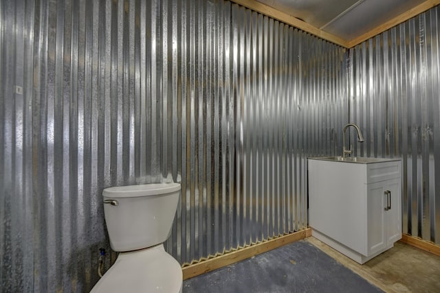 bathroom featuring a sink, toilet, and concrete flooring