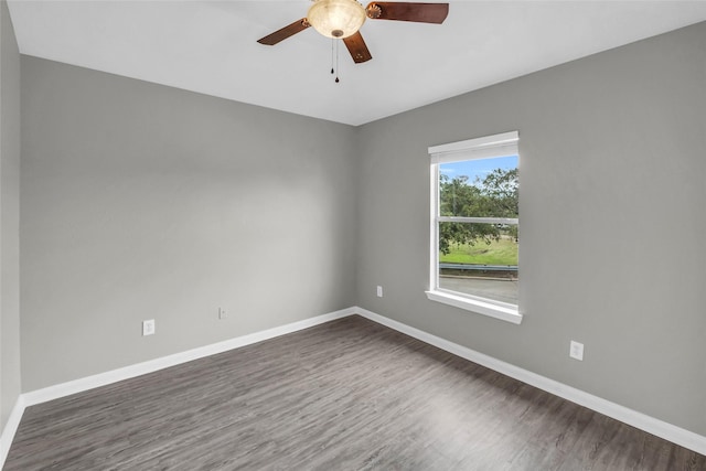 spare room featuring ceiling fan, baseboards, and dark wood-type flooring