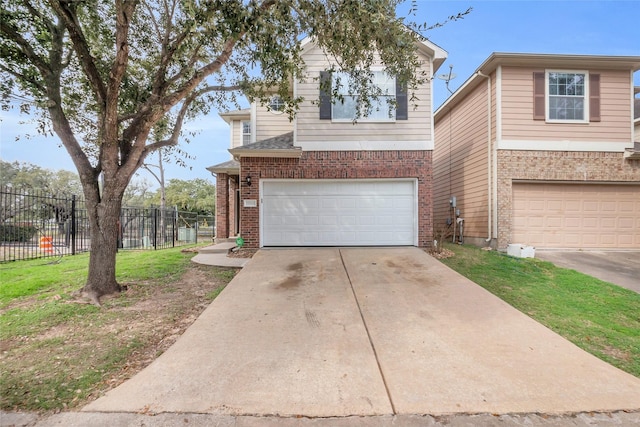 view of front facade with concrete driveway, an attached garage, fence, a front lawn, and brick siding