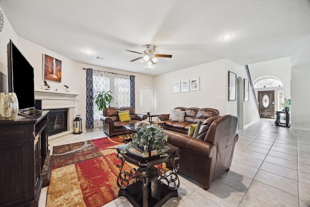 14510 Myers Dr, Houston, TX 77090 - living area featuring light tile patterned floors, a glass covered fireplace, visible vents, and a ceiling fan