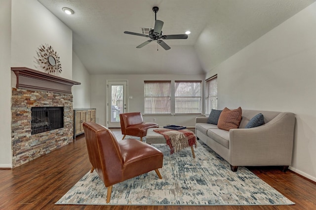 living room featuring lofted ceiling, visible vents, a fireplace, and wood finished floors