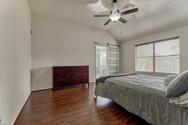 bedroom featuring a barn door, visible vents, baseboards, lofted ceiling, and wood finished floors